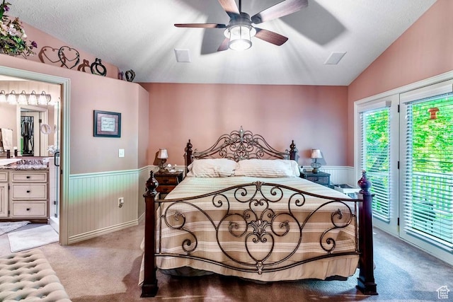 4862 S Kiwana Dr, South Ogden, UT 84403 - bedroom with vaulted ceiling, access to outside, wainscoting, light colored carpet, and ensuite bath