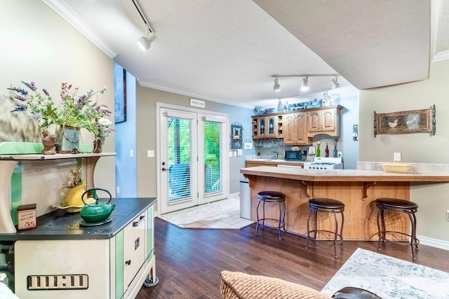 4862 S Kiwana Dr, South Ogden, UT 84403 - kitchen with track lighting, ornamental molding, a kitchen bar, wood finished floors, and a peninsula