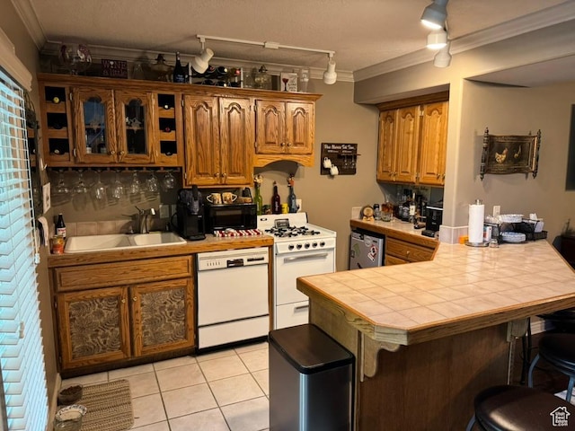 4862 S Kiwana Dr, South Ogden, UT 84403 - kitchen with white appliances, crown molding, a breakfast bar area, tile counters, and a peninsula