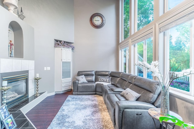 4862 S Kiwana Dr, South Ogden, UT 84403 - living room featuring a high ceiling, baseboards, a tiled fireplace, and dark wood finished floors