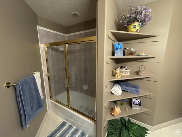 4862 S Kiwana Dr, South Ogden, UT 84403 - bathroom featuring a textured ceiling and combined bath / shower with glass door