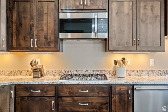 588 S 100 E, Mantua, UT 84324 - kitchen with stainless steel appliances, dark brown cabinetry, and light stone countertops
