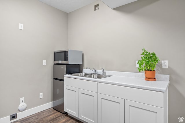 588 S 100 E, Mantua, UT 84324 - kitchen featuring stainless steel microwave, a sink, white cabinetry, dark wood-style flooring, and baseboards