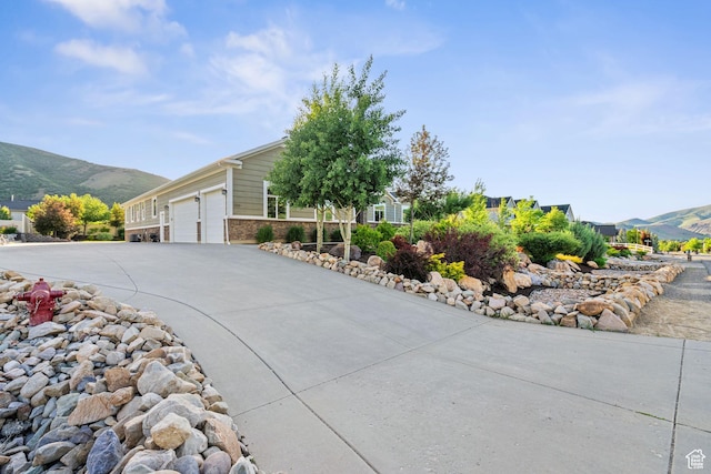 588 S 100 E, Mantua, UT 84324 - view of home's exterior with a mountain view, driveway, an attached garage, and brick siding