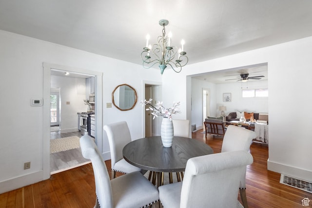 1240 W Indiana Ave, Salt Lake City, UT 84104 - dining area featuring dark wood-style flooring, a chandelier, ceiling fan, and baseboards
