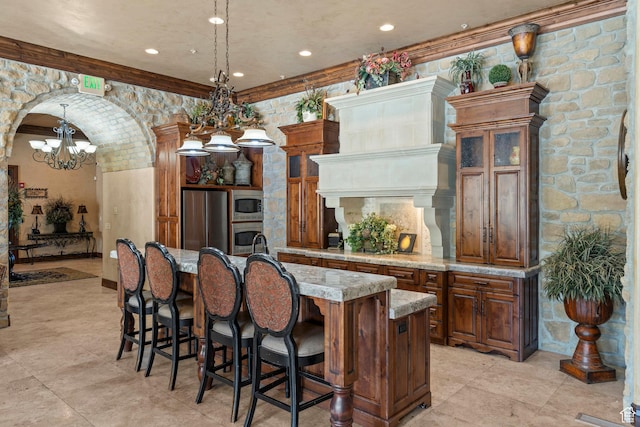 923 W 965 N, Orem, UT 84057 - kitchen with stainless steel appliances, a chandelier, a breakfast bar, a center island with sink, and brown cabinets