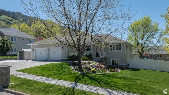 1536 E Mountain Rd, Logan, UT 84321 - view of front of house with concrete driveway, stucco siding, a garage, a mountain view, and a storage unit