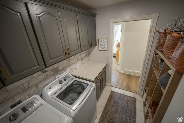 1536 E Mountain Rd, Logan, UT 84321 - laundry room featuring washing machine and clothes dryer, cabinet space, and light tile patterned floors