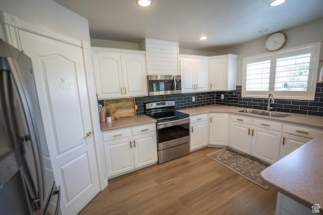 1536 E Mountain Rd, Logan, UT 84321 - kitchen featuring appliances with stainless steel finishes, a sink, white cabinetry, backsplash, and recessed lighting