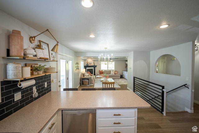1536 E Mountain Rd, Logan, UT 84321 - kitchen featuring stainless steel dishwasher, white cabinetry, a peninsula, wood finished floors, and tasteful backsplash