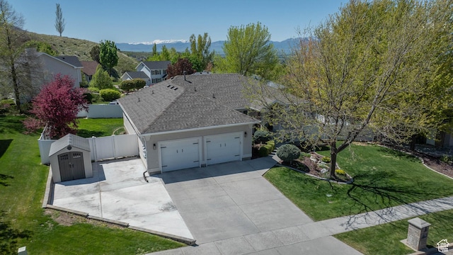 1536 E Mountain Rd, Logan, UT 84321 - view of front of house with a garage, concrete driveway, a mountain view, and a shingled roof