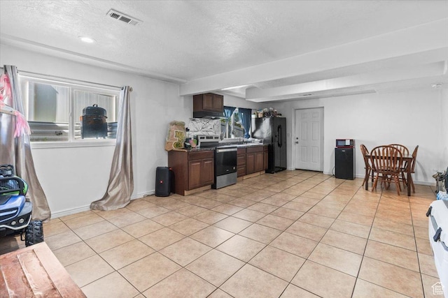 6731 S Ticklegrass Rd W, West Jordan, UT 84081 - kitchen featuring electric range, freestanding refrigerator, light tile patterned flooring, a textured ceiling, and plenty of natural light