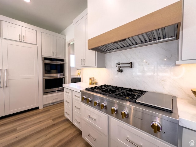 4893 W Ridge Rock Cir, Herriman, UT 84096 - kitchen with premium range hood, stainless steel appliances, light countertops, tasteful backsplash, and white cabinets