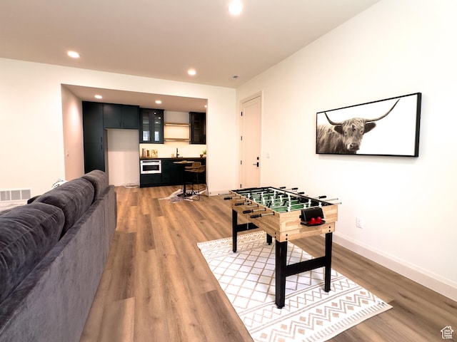 4893 W Ridge Rock Cir, Herriman, UT 84096 - game room featuring light wood-style floors, bar with sink, recessed lighting, and baseboards