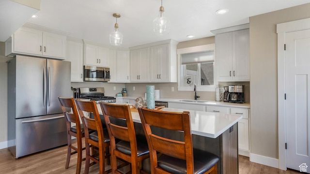 101 E 1500 N, North Ogden, UT 84404 - kitchen with stainless steel appliances, a sink, light wood-type flooring, a center island, and light countertops