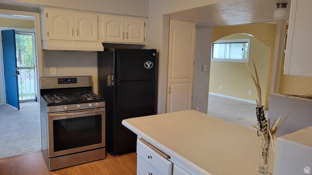 902 W 500 N, Provo, UT 84601 - kitchen featuring stainless steel range with gas cooktop, freestanding refrigerator, under cabinet range hood, white cabinets, and healthy amount of natural light