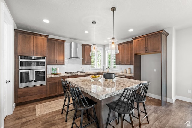 10685 S Dielsdorf Rd E, Sandy, UT 84092 - kitchen featuring wall chimney exhaust hood, stainless steel appliances, wood finished floors, baseboards, and recessed lighting