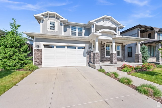 10685 S Dielsdorf Rd E, Sandy, UT 84092 - craftsman house with stone siding, concrete driveway, an attached garage, a porch, and board and batten siding