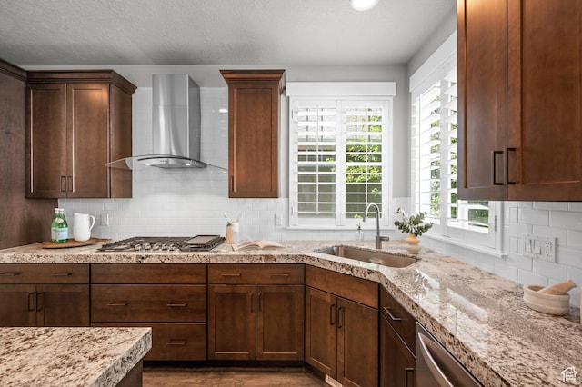 10685 S Dielsdorf Rd E, Sandy, UT 84092 - kitchen featuring wall chimney range hood, stainless steel appliances, a sink, decorative backsplash, and light stone counters