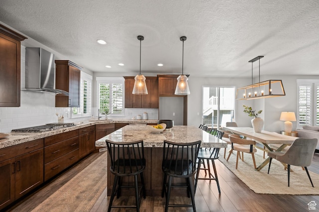 10685 S Dielsdorf Rd E, Sandy, UT 84092 - kitchen with wall chimney exhaust hood, stainless steel gas cooktop, dark wood-type flooring, a textured ceiling, and a sink
