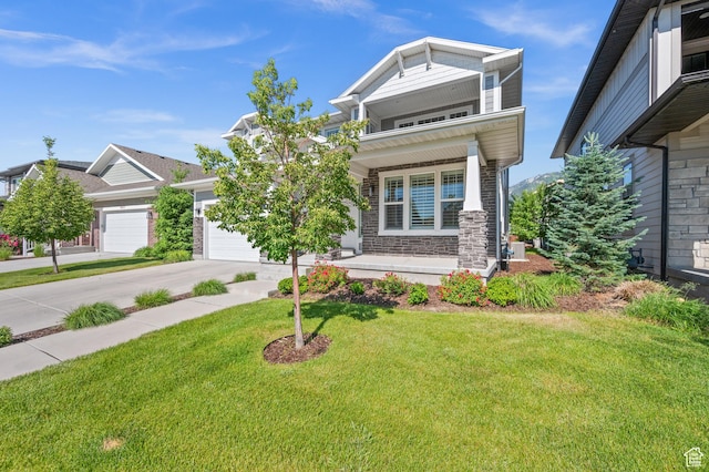 10685 S Dielsdorf Rd E, Sandy, UT 84092 - view of front of house with a porch, concrete driveway, a front yard, a garage, and stone siding