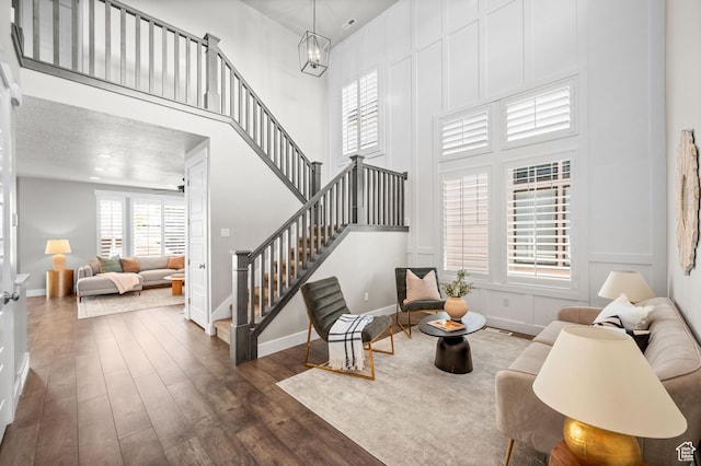 10685 S Dielsdorf Rd E, Sandy, UT 84092 - living room with stairs, wood finished floors, baseboards, a towering ceiling, and a chandelier