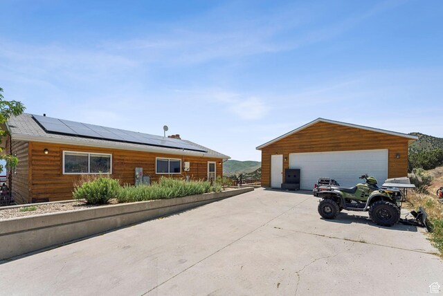 8043 W Hi Country Rd S, Herriman, UT 84096 - view of property exterior with roof mounted solar panels, a garage, and an outbuilding