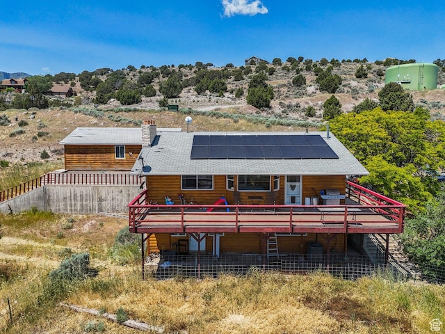 8043 W Hi Country Rd S, Herriman, UT 84096 - back of house with a deck, roof mounted solar panels, and a chimney