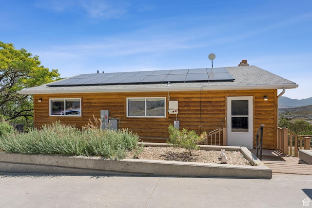 8043 W Hi Country Rd S, Herriman, UT 84096 - view of front of home featuring solar panels, roof with shingles, a deck, and a chimney
