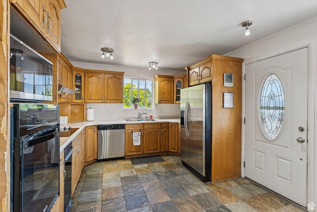 8043 W Hi Country Rd S, Herriman, UT 84096 - kitchen with appliances with stainless steel finishes, brown cabinetry, a sink, light countertops, and stone finish floors