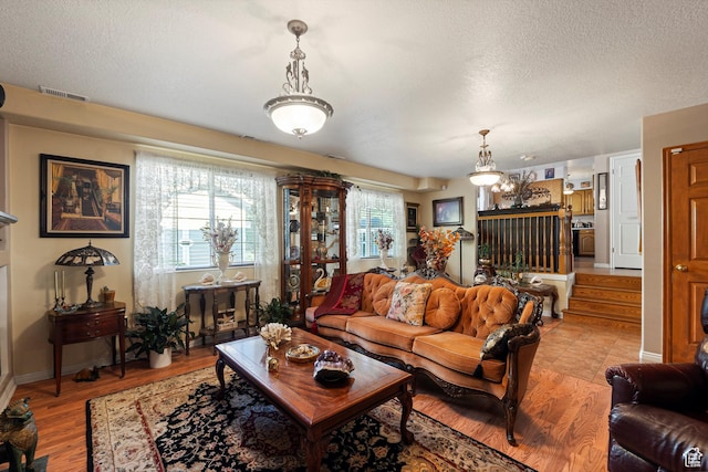 963 E 1275 N, Ogden, UT 84404 - living area with a textured ceiling, light wood finished floors, baseboards, a chandelier, and stairway