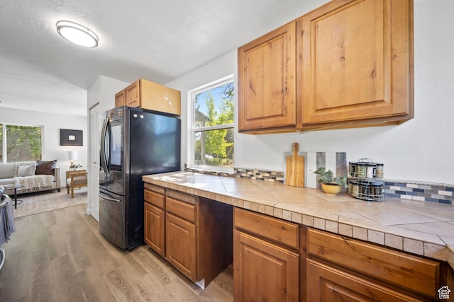 5111 S 1000 E, Murray, UT 84117 - kitchen with freestanding refrigerator, plenty of natural light, light wood-style flooring, and tile counters