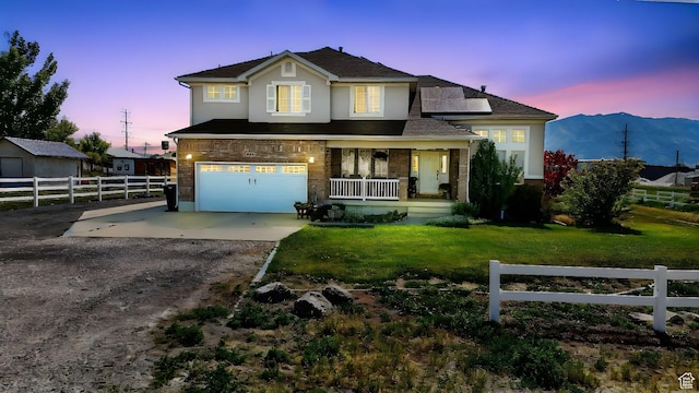 913 N 2300 W, Tremonton, UT 84337 - traditional home featuring covered porch, driveway, a garage, roof mounted solar panels, and stucco siding