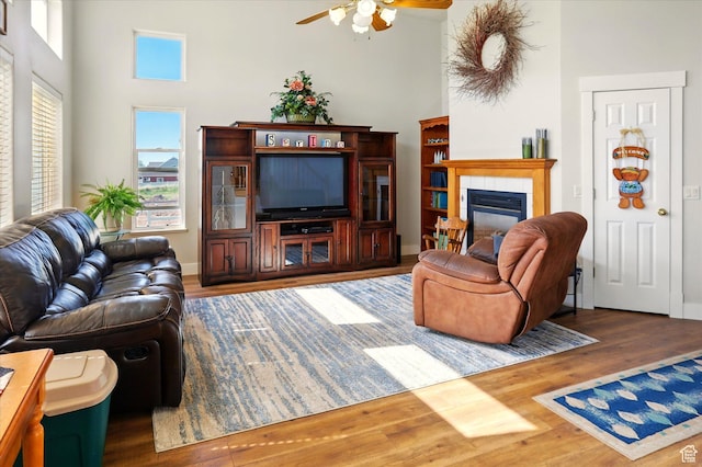 913 N 2300 W, Tremonton, UT 84337 - living area featuring a ceiling fan, wood finished floors, a high ceiling, a fireplace, and baseboards