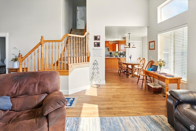 913 N 2300 W, Tremonton, UT 84337 - living area with light wood-style floors, a towering ceiling, stairs, and baseboards