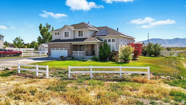 913 N 2300 W, Tremonton, UT 84337 - traditional-style house with driveway, solar panels, a mountain view, a garage, and brick siding