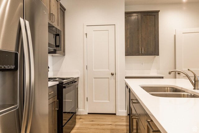 520 S Orchard Dr Unit 17, Bountiful, UT 84010 - kitchen featuring stainless steel fridge with ice dispenser, black gas range, a sink, light countertops, and light wood finished floors