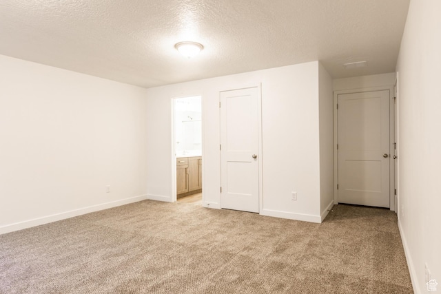 520 S Orchard Dr Unit 17, Bountiful, UT 84010 - unfurnished bedroom with light carpet, a textured ceiling, baseboards, and ensuite bath