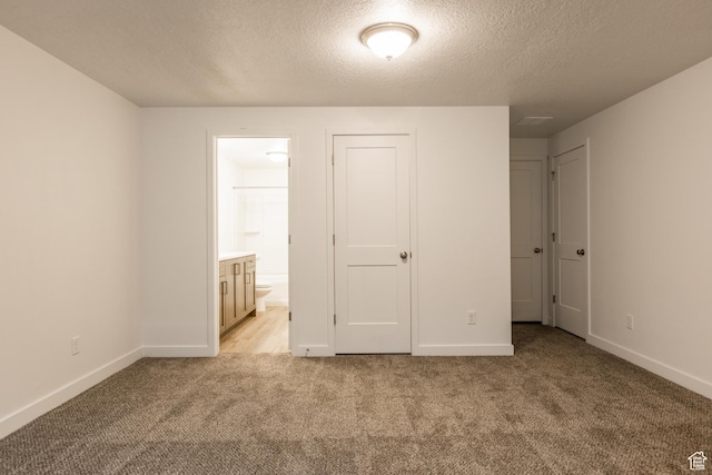 520 S Orchard Dr Unit 17, Bountiful, UT 84010 - unfurnished bedroom with light colored carpet, baseboards, a textured ceiling, and connected bathroom