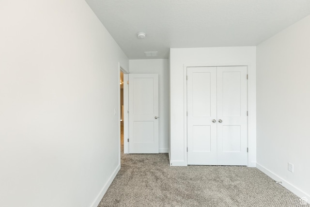 520 S Orchard Dr Unit 17, Bountiful, UT 84010 - unfurnished bedroom with light colored carpet, baseboards, and a closet