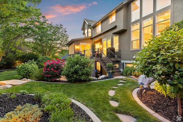 1784 E Ellerbeck Ln, Draper, UT 84020 - back of property at dusk featuring stairway, stucco siding, and a yard
