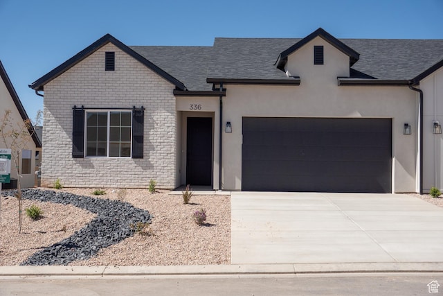 336 W Rosie Loop Unit 45W, Cedar City, UT 84721 - french country home featuring an attached garage, concrete driveway, and roof with shingles