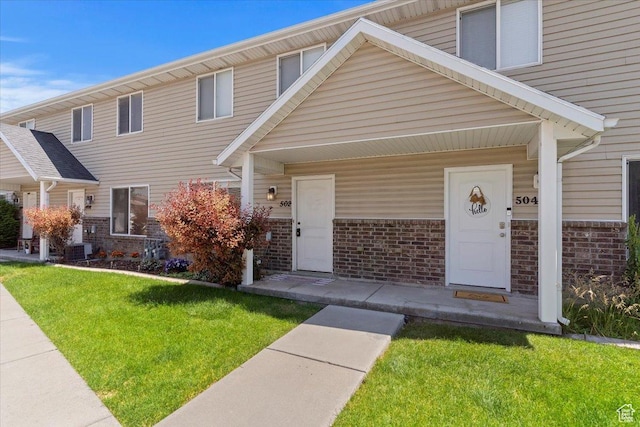 502 E 475 N, Ogden, UT 84404 - view of property featuring brick siding, a front yard, a porch, and central AC unit