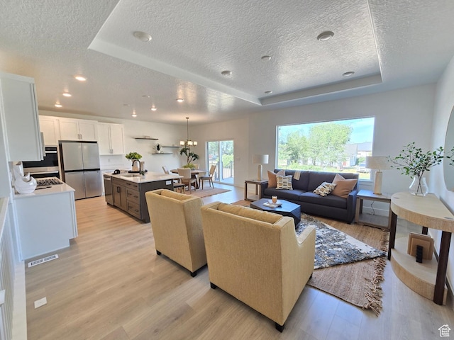4286 W 1600 S Unit 301, Ogden, UT 84404 - living area featuring a textured ceiling, a raised ceiling, light wood-type flooring, and recessed lighting