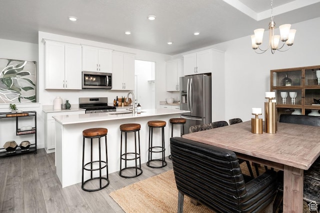 4286 W 1600 S Unit 301, Ogden, UT 84404 - kitchen with appliances with stainless steel finishes, a sink, a kitchen breakfast bar, light wood-style floors, and recessed lighting