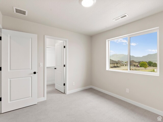 1597 N Cozy Ln Unit 14, Saratoga Springs, UT 84045 - unfurnished bedroom featuring light carpet, a mountain view, a spacious closet, and a closet