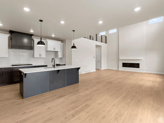 1597 N Cozy Ln Unit 14, Saratoga Springs, UT 84045 - kitchen with custom exhaust hood, light countertops, an island with sink, recessed lighting, and a breakfast bar
