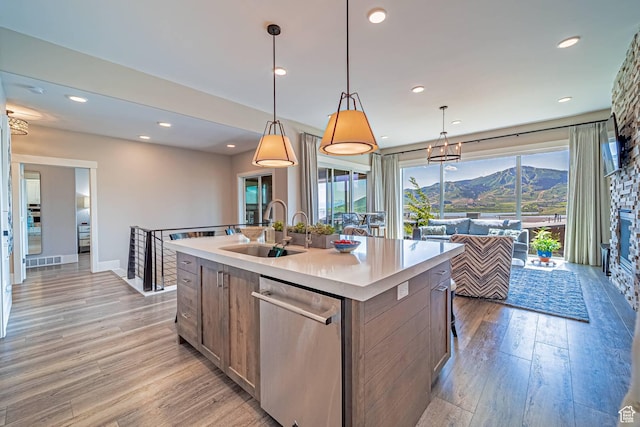 11517 N Perspective Dr, Hideout, UT 84036 - kitchen featuring a sink, stainless steel dishwasher, light wood finished floors, a center island with sink, and light countertops