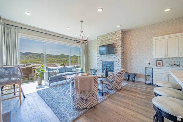 11517 N Perspective Dr, Hideout, UT 84036 - living room featuring a chandelier, light wood-style flooring, a stone fireplace, recessed lighting, and wallpapered walls