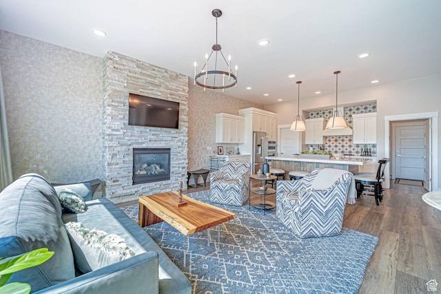 11517 N Perspective Dr, Hideout, UT 84036 - living room featuring wood finished floors, a chandelier, wallpapered walls, recessed lighting, and a stone fireplace